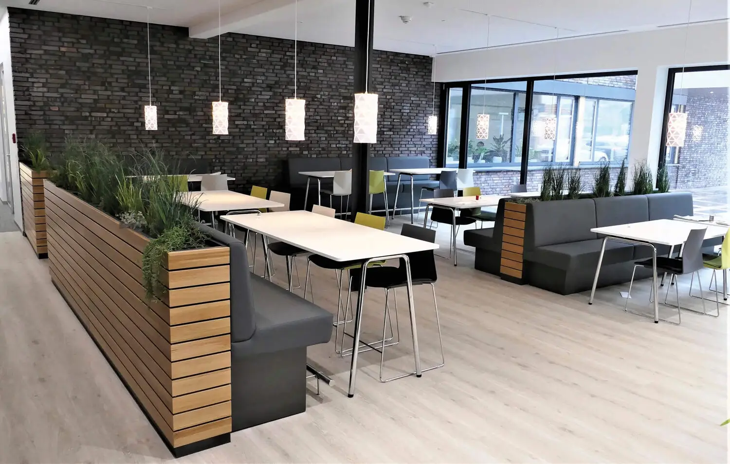 Bistroähnliche Kantine mit gemütlichen Sitzgruppen und warmen Farben